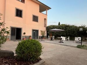a building with a table and chairs and an umbrella at Agriturismo Domus Tuscia in Viterbo