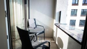 balcón con sillas, mesa y ventana en Downtown28 apartment, en Poprad