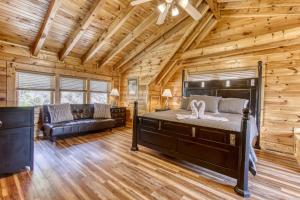 een slaapkamer in een blokhut met een bed en een bank bij Dream Come True #555 in Pigeon Forge +45 foto's