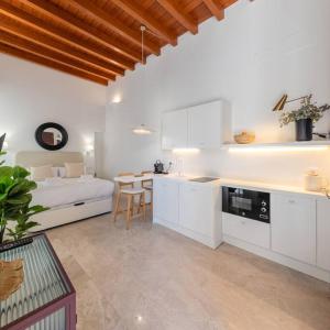 a white kitchen with a bed and a table at ISG apartments Puerta Jerez Sevilla 02 in Seville