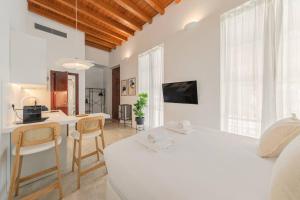 a bedroom with a bed and a kitchen and a desk at ISG apartments Puerta Jerez Sevilla 02 in Seville +56 photos