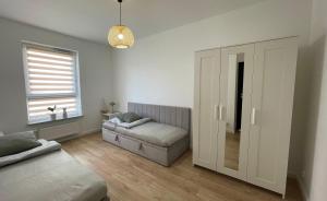 a living room with a couch and a window at Oaza Przystań in Giżycko