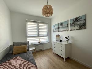 a bedroom with a bed and a dresser and a window at Oaza Przystań in Giżycko