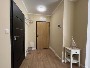 a hallway with a door and a table and a desk at Oaza Przystań in Giżycko