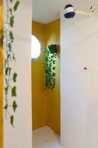 a room with yellow walls and a plant at La Bohème Casa Cultural - Santa Teresa in Rio de Janeiro
