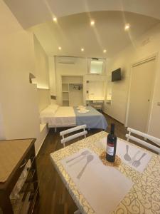 a room with two beds and a table with a bottle of wine at San Francesco Tropea Accomodation in Tropea