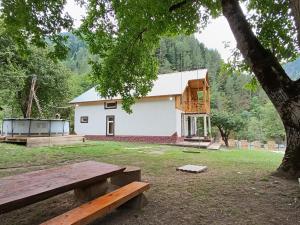 a house with a bench in front of it at Green Wood In Ifari in Kveda-Ipari