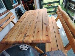 un tavolo in legno con 2 sedie e una griglia di Leśna Chata kuracyjna nad rzeką z sauną w Borach Tucholskich a Bielska Struga Altre 101 foto
