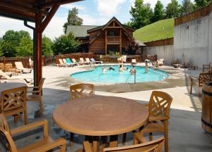 a pool with a table and chairs and people in it at Farmers Retreat #221 in Sevierville