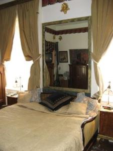 1 dormitorio con cama con dosel y espejo grande en Imre Guest House, en Budapest