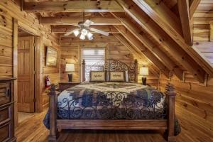 a bedroom in a log cabin with a bed and a ceiling fan at Farmers Retreat #221 in Sevierville +26 photos