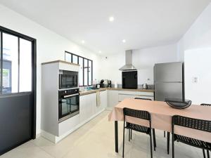 a kitchen with a table and chairs and a kitchen with appliances at L'Échappée Belle Élégance, Familiale, Conviviale in Torfou