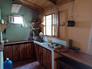 a kitchen with a stove and a sink and a window at Casita in Mindo village, Ecuador in Mindo