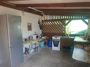 a kitchen with a white refrigerator and a stove at Domek GLAMPING na Polu namiotowym RADOŚĆ in Okuninka