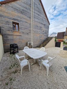 a white table and two chairs and a grill at Maisonnette de la Butte de Thil in Nan-sous-Thil