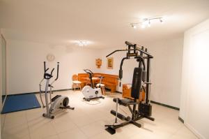 un gimnasio con equipamiento de ejercicio en una habitación en Garni Hotel Sonnleitenhof, en Caldaro