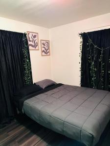 1 dormitorio con 1 cama con cortinas negras en Zen Home, en Santa Ana