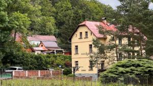 a large yellow house with a red roof at Chata Plechovka in Česká Lípa