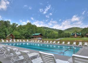 a swimming pool with white chairs and a bunch ofitures at Honey Bear Hill #326 in Sevierville