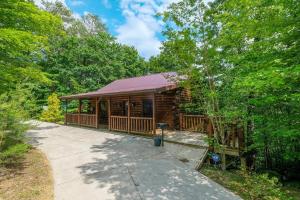 a cabin in the woods with a walkway in front at Jackson's Starry Nite Sky #217 in Sevierville