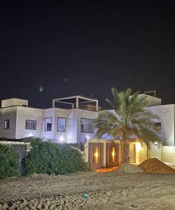 una casa con una palma di fronte ad essa di notte di Mamy Residence a Nouakchott