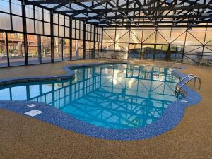 a large swimming pool in a building with windows at Kissing Retreat #269 in Sevierville