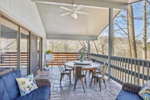 Un porche cubierto con una mesa, sillas y un ventilador de techo. en Gatlinburg - Barbara's Song #4125, en Gatlinburg