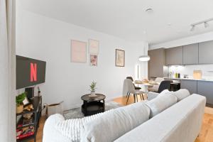 Una sala de estar con un sofá blanco y una cocina. en WHONAP - PINK LION I Parkplatz I Zentral I Terrasse I Küche I Business, en Neckarsulm