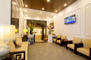 a lobby with a waiting room with chairs and a television at Hanoi Luxury Hotel in Hanoi