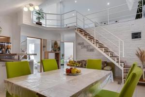 a dining room with a table and green chairs at Ferienwohnung Luna mit Pool in Brinje