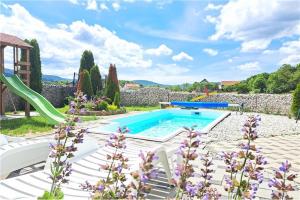 a swimming pool in a garden with purple flowers at Ferienwohnung Luna mit Pool in Brinje