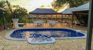 a swimming pool with a table and a tent at Studio pistache 2 personnes in Le Lamentin