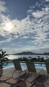 a group of chairs sitting next to a swimming pool at Habitación de lujo en Pacífica Resort Ixtapa in Ixtapa