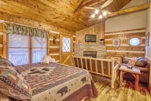 a log cabin bedroom with a bed and a fireplace at Moonshine Madness #1611 in Gatlinburg