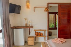 a room with a tv on the wall and a table at Araxá Milagres in São Miguel dos Milagres