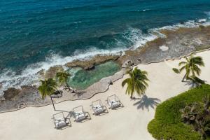 een luchtzicht op een strand met stoelen en palmbomen bij Dreams Aventuras Riviera Maya - All Inclusive in Puerto Aventuras