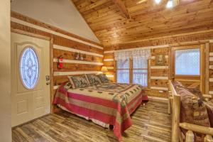 a bedroom in a log cabin with a bed and a door at Puppy Love #1619 in Gatlinburg