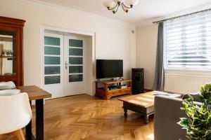 a living room with a couch and a tv at Villa Plater in Olsztyn