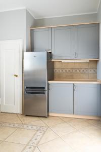 a kitchen with a stainless steel refrigerator and cabinets at Villa Plater in Olsztyn