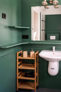 a green bathroom with a sink and a mirror at Villa Plater in Olsztyn +14 photos