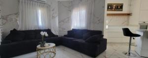 un soggiorno con un divano e un tavolo di Penthouse in Ramat Gan Next to Sheba Hospital a Ramat Gan