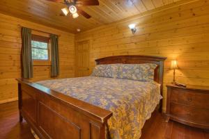 Un dormitorio con una cama en una cabaña de troncos en Skinny Dippin' #261, en Pigeon Forge 23 fotos más