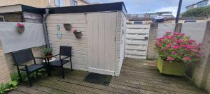 a wooden deck with two chairs and a fence with flowers at Casa de Deborah in Zandvoort