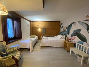 una habitación de hotel con dos camas y un sofá en Apartamentos María Luisa, en Burgos