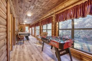 una sala de juegos con futbolín en una cabaña de madera en Suite Spot #242, en Pigeon Forge
