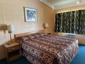 a hotel room with a bed and a window at Fireside Inn in King City
