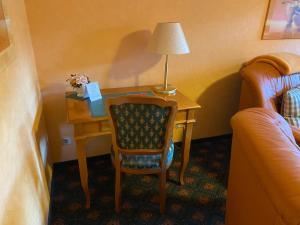 a room with a desk with a chair and a lamp at Altstadt-Refugium - Schlossblick, Sauna, Parkplatz, Innenstadt, Wow Sky Sport BL in Wernigerode