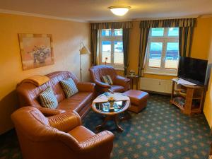 a living room with leather furniture and a television at Altstadt-Refugium - Schlossblick, Sauna, Parkplatz, Innenstadt, Wow Sky Sport BL in Wernigerode