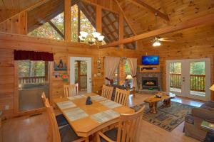 a dining room and living room of a wooden cabin at Wet Bear Paws #146 in Sevierville
