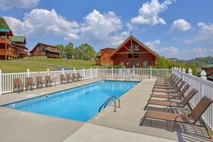 a swimming pool with chairs and a house at Whispering Creek #302 in Pigeon Forge